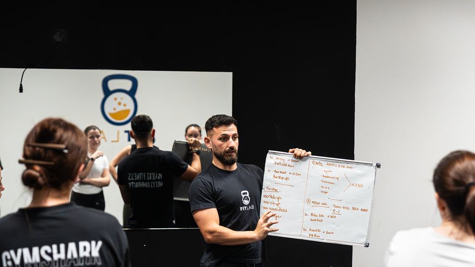 Coach briefing a small group from the whiteboard